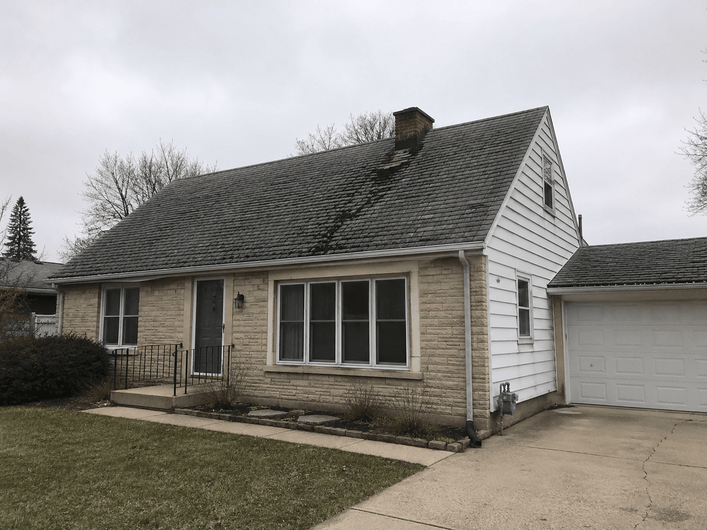 Aging, curling three-tab shingle roof before replacement.